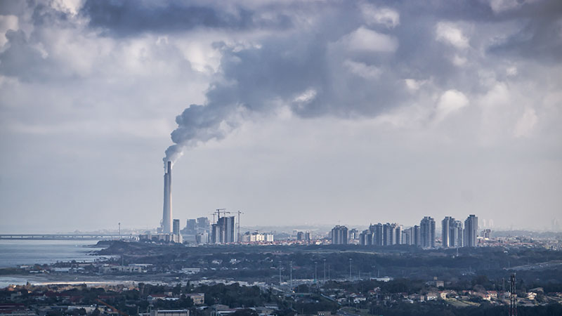 Aerial View of an Industrial Site emitting dark cloud of smoke into the air